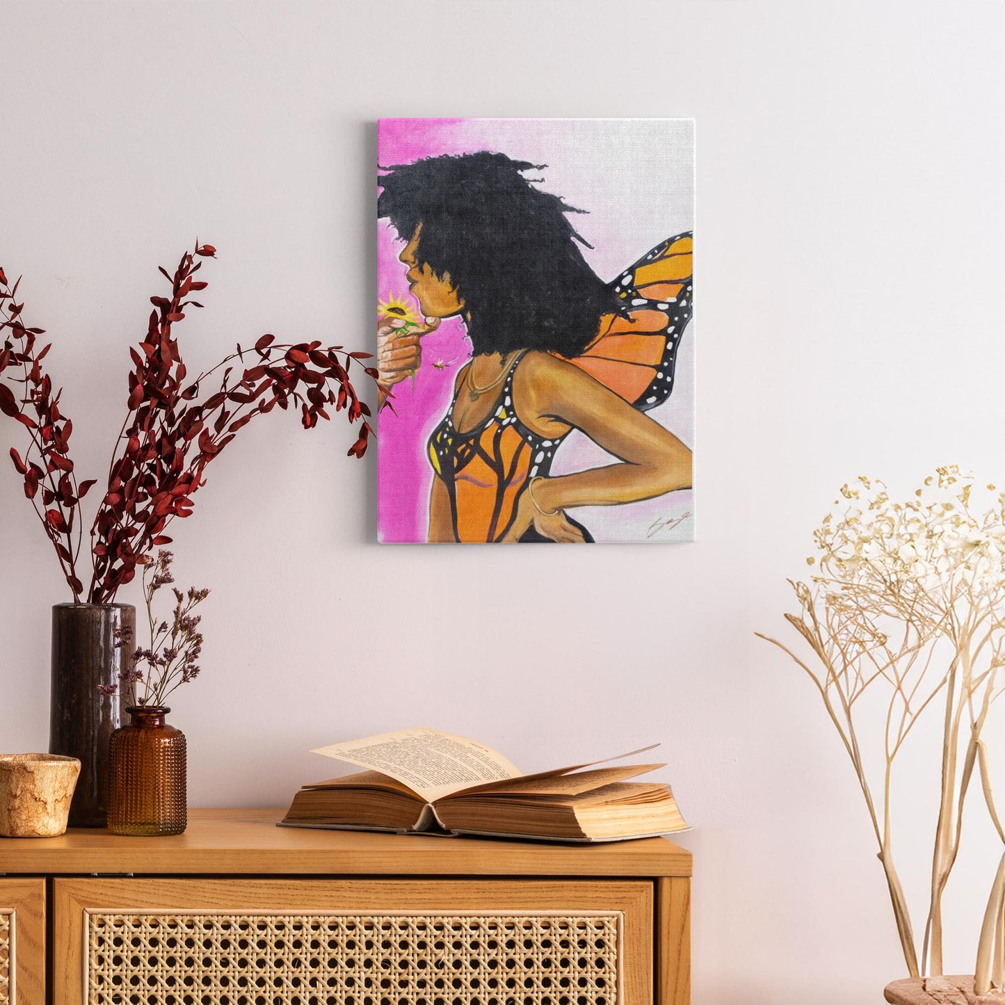 Surreal painting titled “Angelic Butterfly” showing a male hand holding a sunflower toward a Black woman depicted as a butterfly, symbolizing love and transformation.