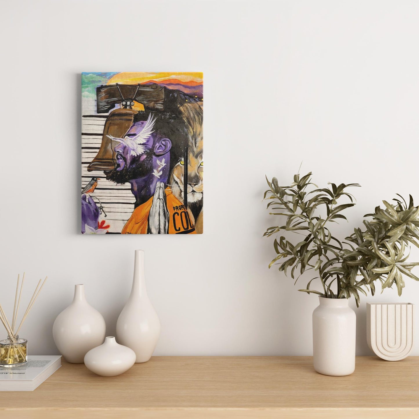 Painting titled “Give Me Liberty” showing a male in a prison jumpsuit kneeling in prayer with a symbolic lion behind bars, liberty bell, and doves representing freedom.