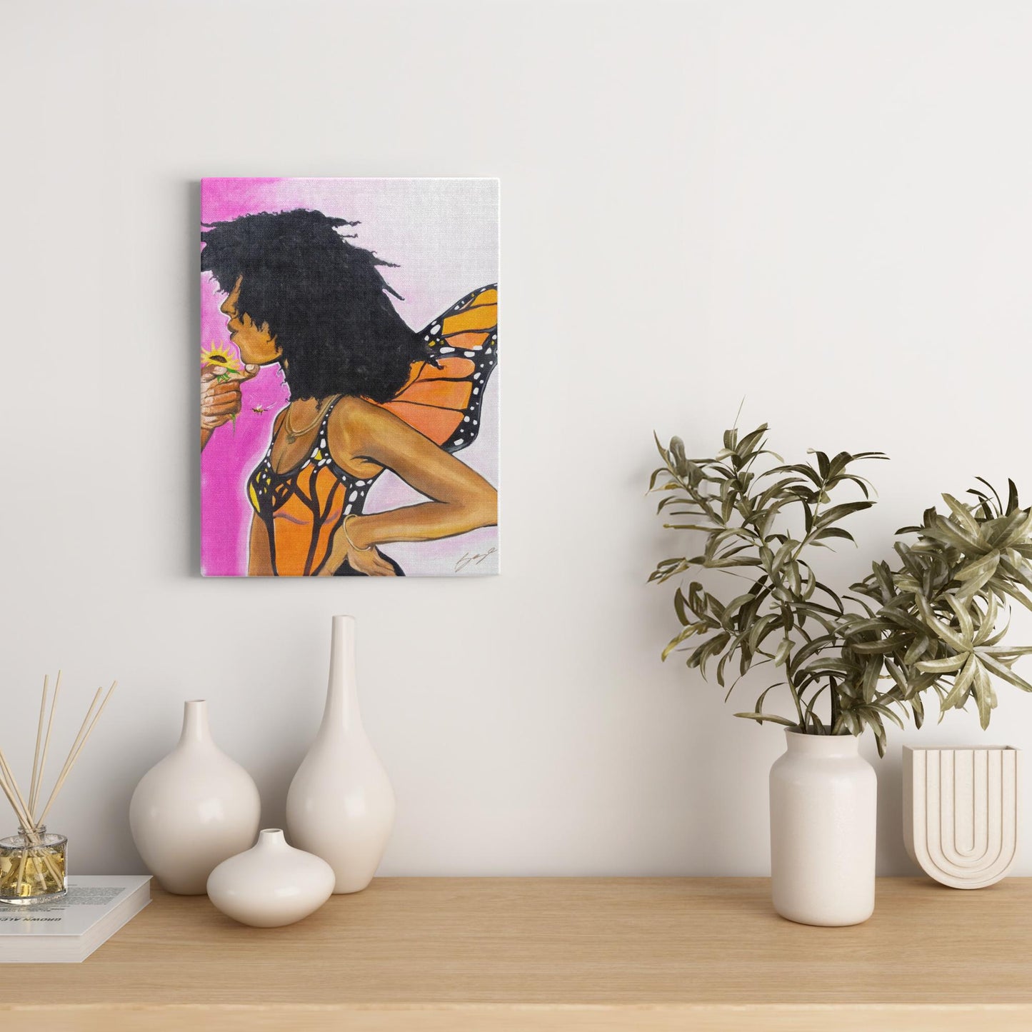 Surreal painting titled “Angelic Butterfly” showing a male hand holding a sunflower toward a Black woman depicted as a butterfly, symbolizing love and transformation.