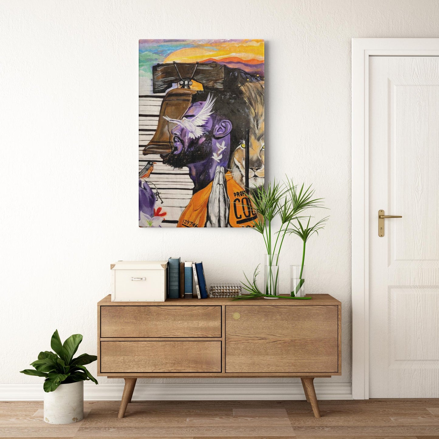 Painting titled “Give Me Liberty” showing a male in a prison jumpsuit kneeling in prayer with a symbolic lion behind bars, liberty bell, and doves representing freedom.